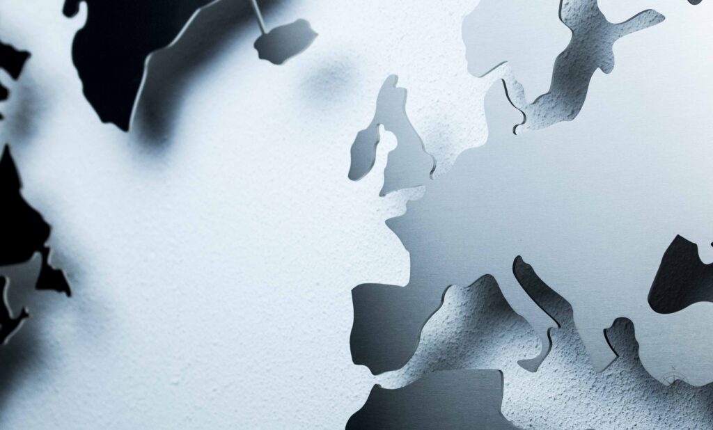 Weltkarte aus Edelstahl vor einer weißen Wand (Ansicht Detail)