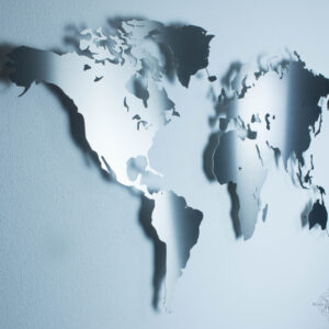 Weltkarte aus Edelstahl vor einer weißen Wand (Ansicht Links)