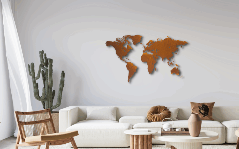 Weltkarte rostig vor einer weissen Wand. Im Wohnzimmer mit einem hellen Sofa. Es ist auch ein Kaktus zu sehen.