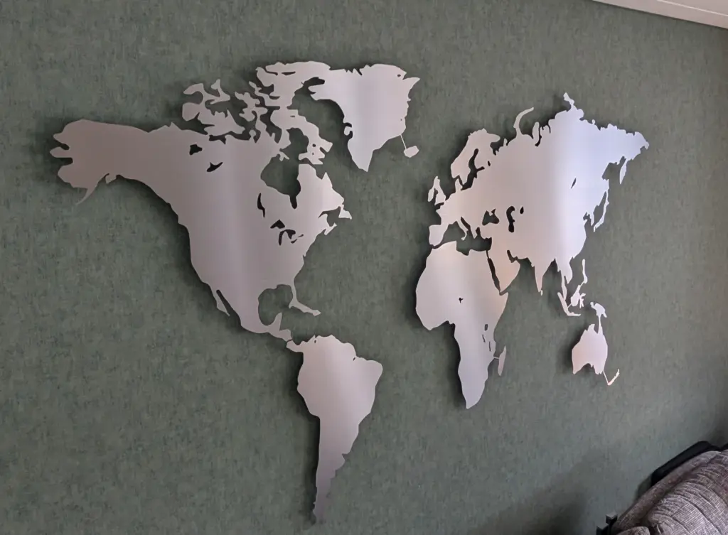 Weltkarte beleuchtet aus Edelstahl in Größe L auf grüner Wand