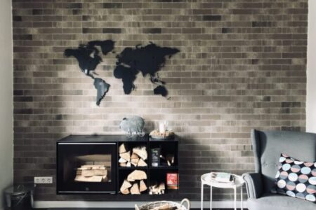 Anthrazite Weltkarte in einem Wohnzimmer oberhalb eines Kamins. Es ist noch ein toller Sessel zus ehen