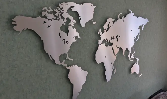 Weltkarte beleuchtet aus Edelstahl in Größe L auf grüner Wand