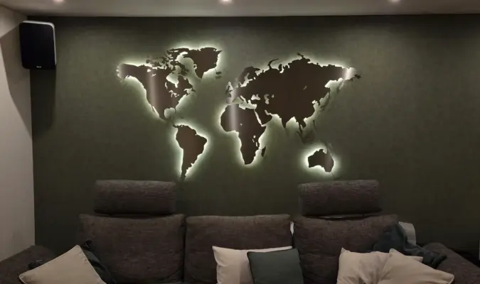 Weltkarte beleuchtet aus Metall im Wohnzimmer auf dunkelgrüner Wand