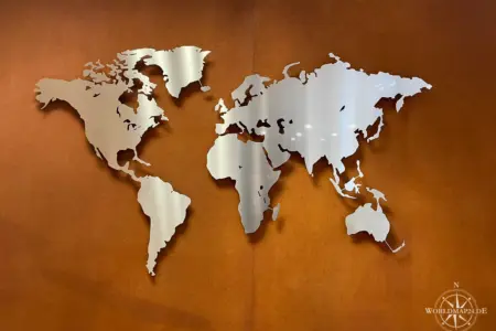 Weltkarte aus Edelstahl auf einer rostigen Wand