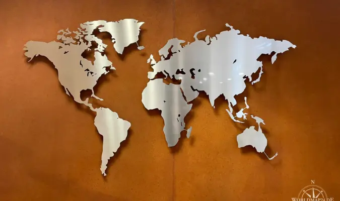 Weltkarte aus Edelstahl auf einer rostigen Wand