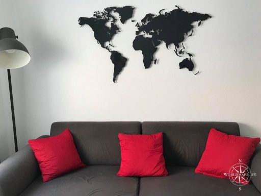 Kundenbild Weltkarte Anthrazitgrau in einem Wohnzimmer. Im Vordergrund ist ein dunkelgraues Sofa mit roten Kissen zu sehen