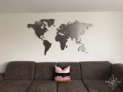 Kundenbild Weltkarte Eisenglimmer in einem Wohnzimmer. Im Vordergrund befindet sich ein dunkelgraues Sofa